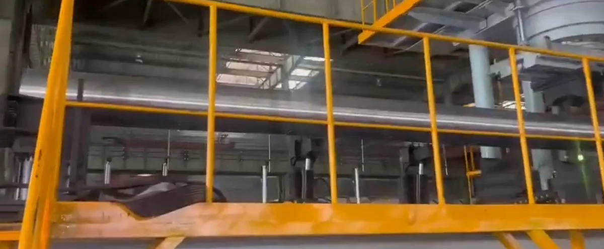 Long seamless steel pipe supported through a hydraulic straightening station