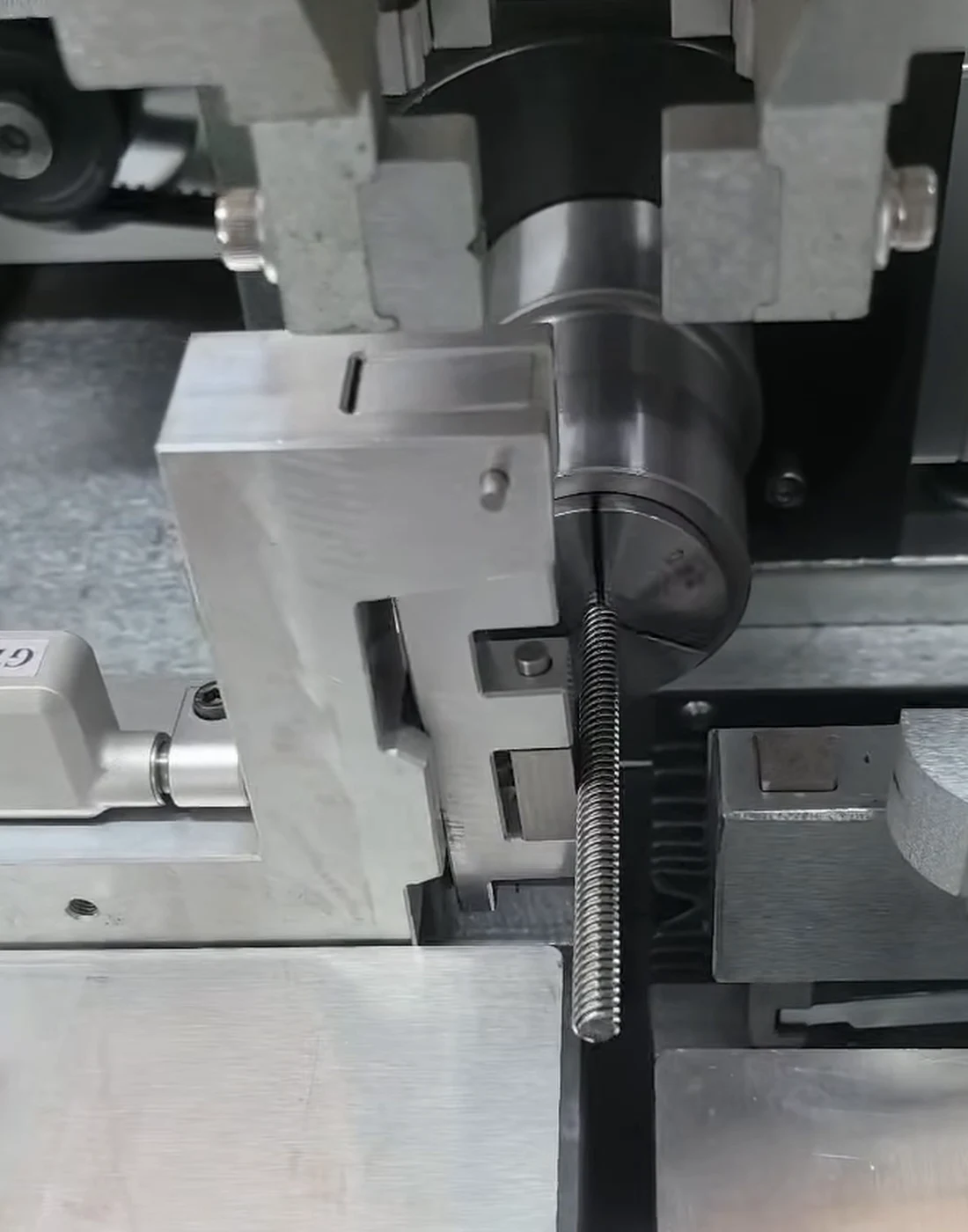 Threaded lead screw held by a rotating fixture during straightening